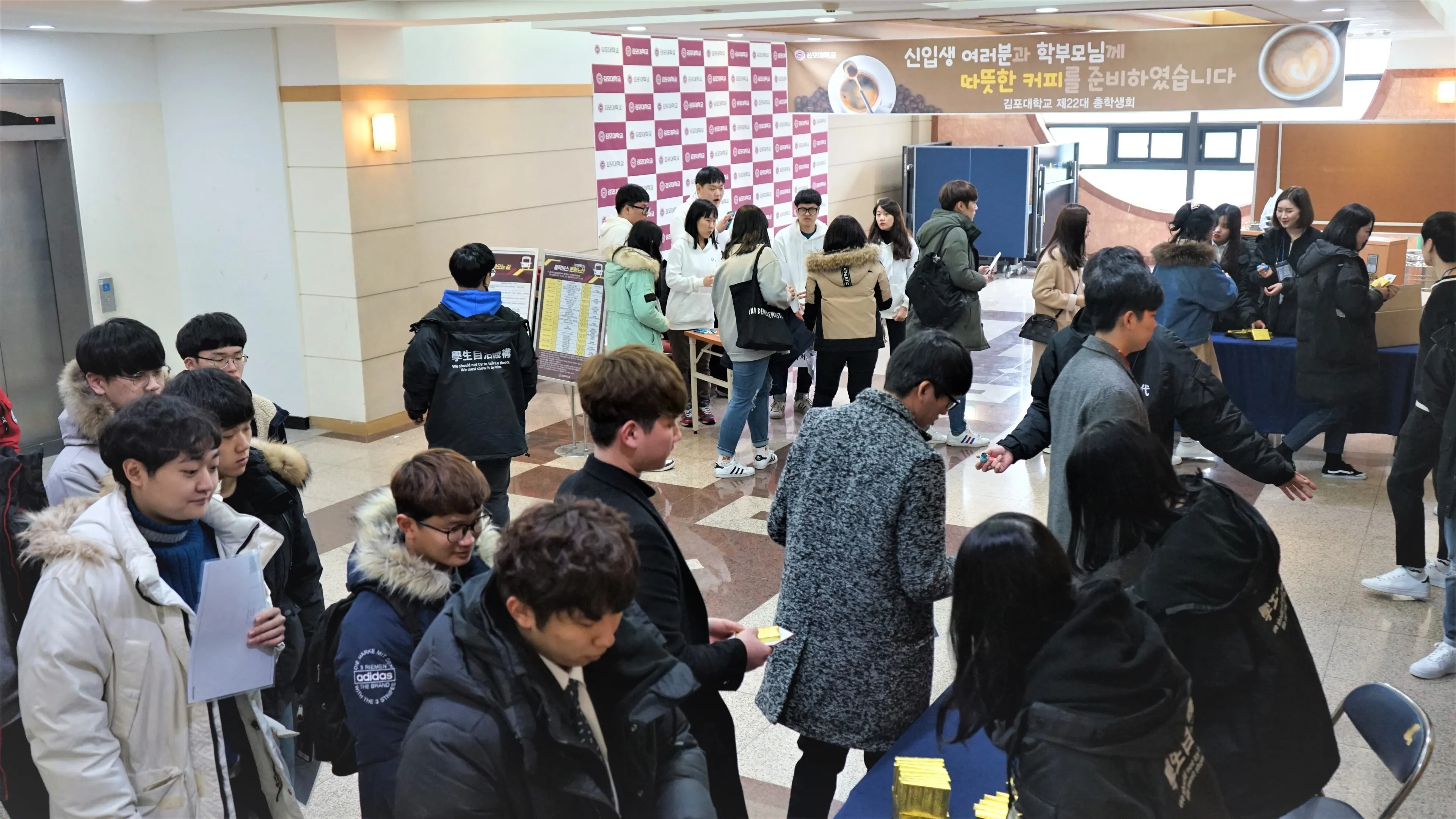 웰컴 커피 현수막이 걸린 로비에서 줄을 서 등록하는 신입생들