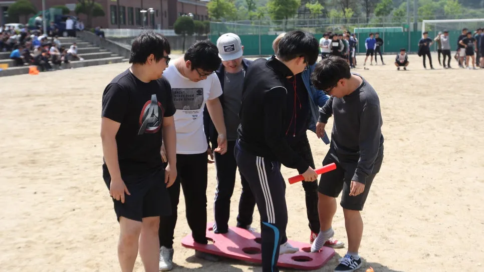 운동장에서 발판 위에 함께 올라선 학생들과 배턴을 든 참가자